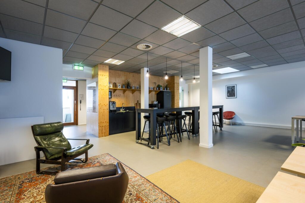 Moderne, open kantoorkeuken met zithoek aan de De Ruijterkade.